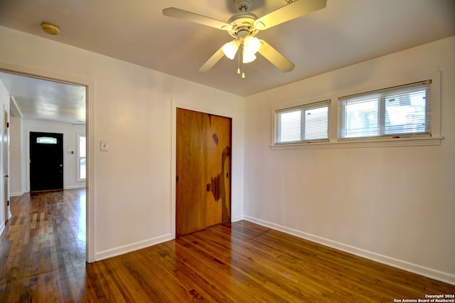 unfurnished bedroom with a closet, ceiling fan, and dark hardwood / wood-style flooring