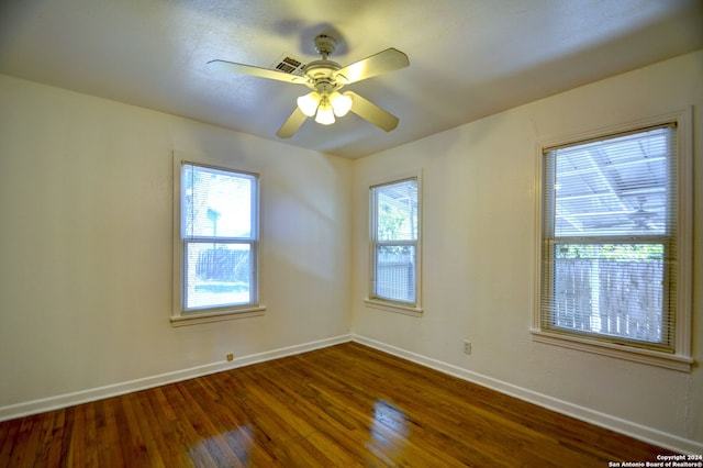 empty room with ceiling fan and dark hardwood / wood-style flooring