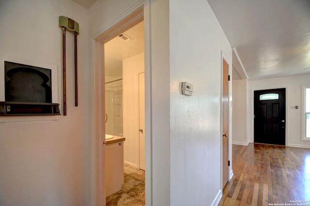 corridor with light hardwood / wood-style floors