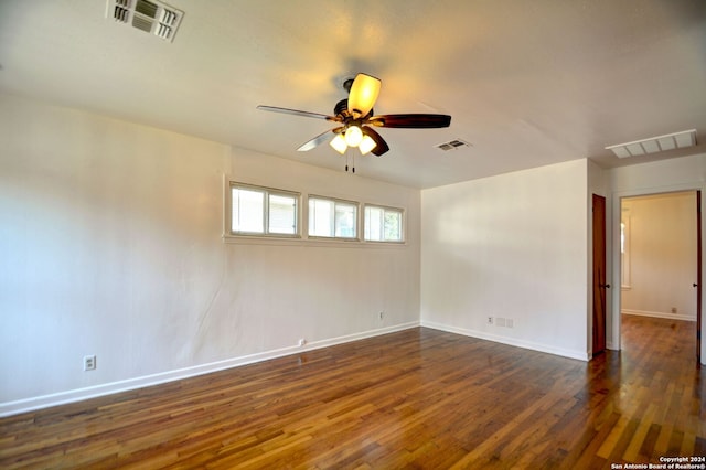 spare room with dark wood-type flooring and ceiling fan