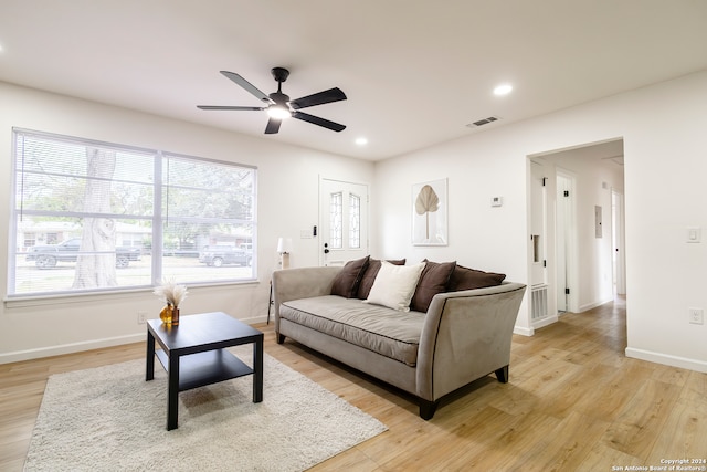 living room with light hardwood / wood-style flooring and ceiling fan