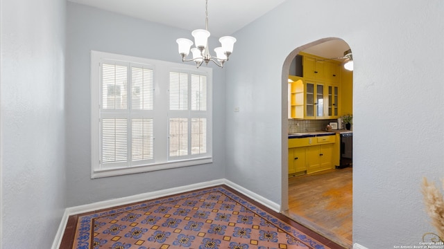 dining area with hardwood / wood-style flooring and ceiling fan with notable chandelier