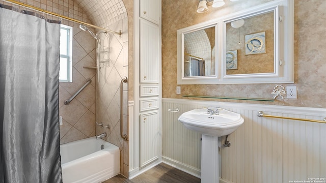 bathroom with hardwood / wood-style flooring and shower / bathtub combination with curtain