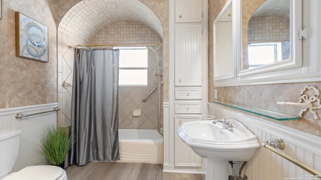 full bathroom featuring lofted ceiling, hardwood / wood-style flooring, toilet, shower / bath combo, and sink