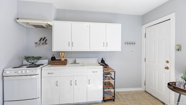 kitchen featuring sink, white cabinets, white stove, and light tile patterned floors