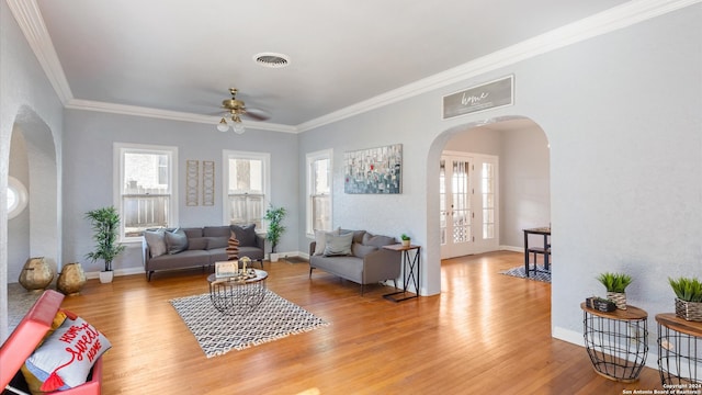 living room with crown molding, wood-type flooring, and ceiling fan