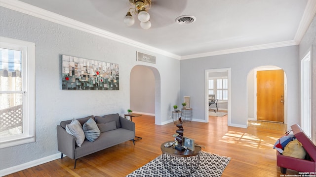 living room with crown molding, hardwood / wood-style flooring, and plenty of natural light