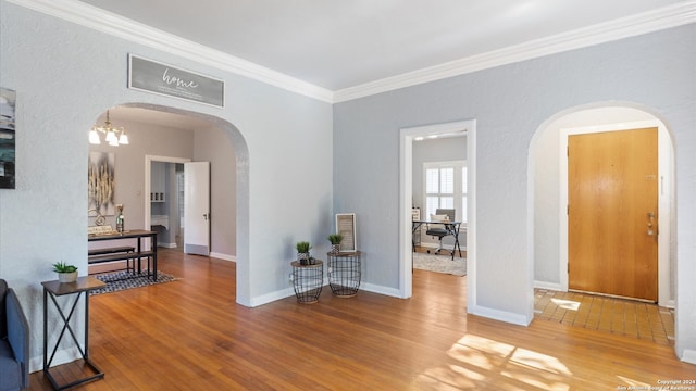 interior space featuring an inviting chandelier, crown molding, and hardwood / wood-style flooring