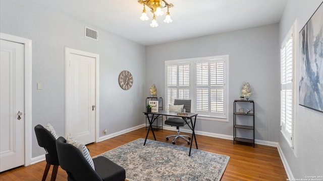 home office with a notable chandelier and hardwood / wood-style flooring