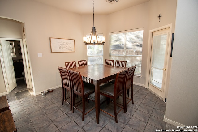 tiled dining room with a notable chandelier