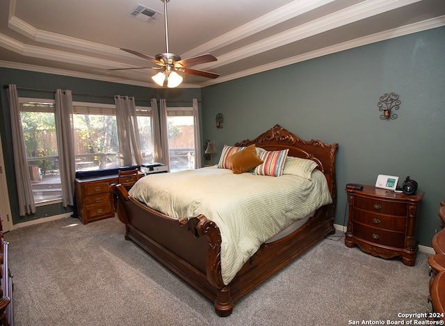 bedroom featuring carpet flooring, ceiling fan, ornamental molding, and a tray ceiling