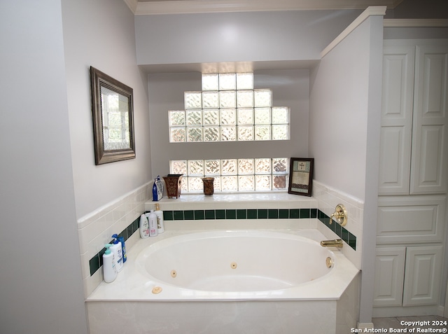 bathroom featuring ornamental molding, a tub, and a wealth of natural light