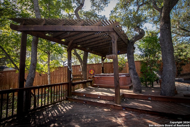 deck featuring a pergola and a hot tub