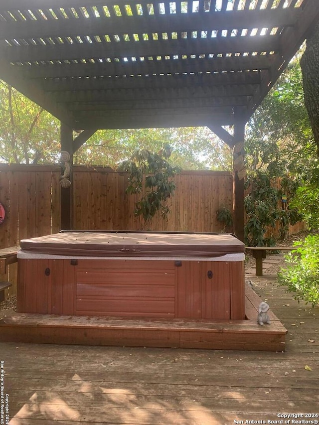 wooden deck featuring a hot tub