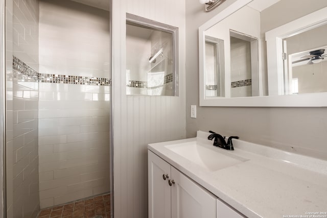 bathroom featuring vanity, a tile shower, and ceiling fan