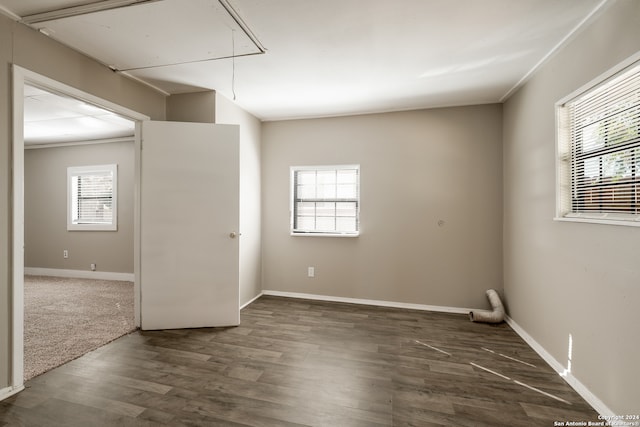 empty room featuring plenty of natural light and dark hardwood / wood-style floors