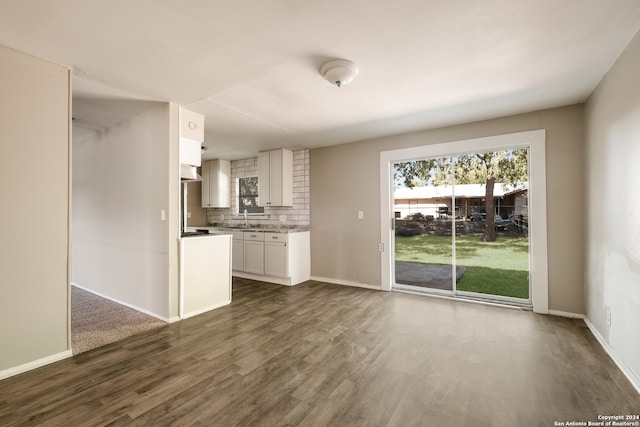 unfurnished living room with sink and dark hardwood / wood-style flooring