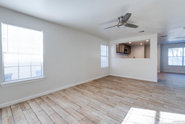 7419 Cedar Farm, San Antonio, TX 78239 - unfurnished living room with baseboards, ceiling fan, light wood-style flooring, and visible vents