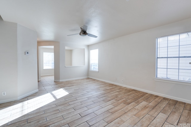 spare room with light wood-type flooring and ceiling fan