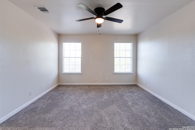 carpeted spare room featuring ceiling fan and a textured ceiling