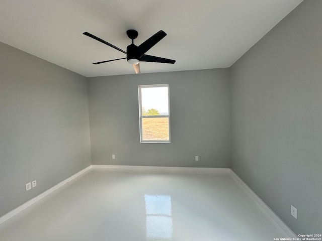 empty room with concrete floors and ceiling fan