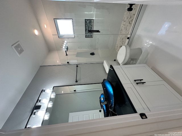 bathroom with tiled shower and toilet