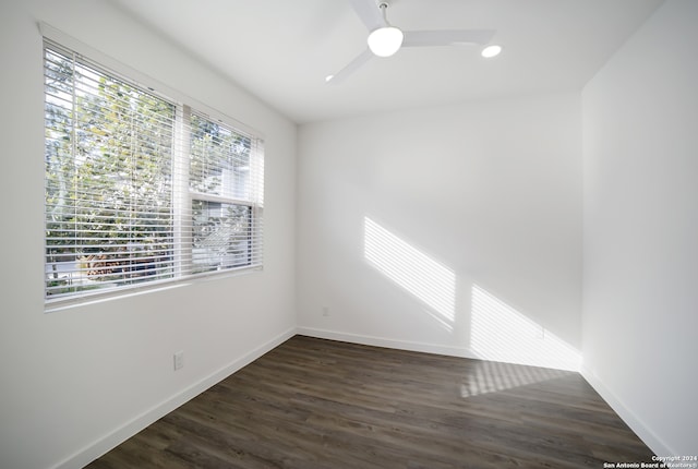 spare room with ceiling fan, a wealth of natural light, and dark hardwood / wood-style floors