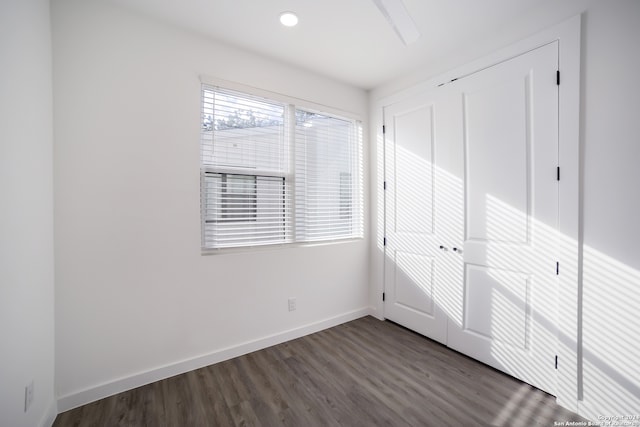 unfurnished bedroom with a closet and dark hardwood / wood-style floors