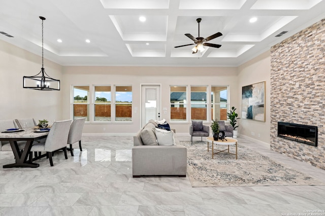 living room with a towering ceiling, ceiling fan with notable chandelier, a fireplace, coffered ceiling, and beamed ceiling