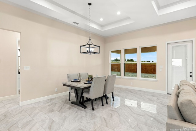 dining room with crown molding, a chandelier, and a raised ceiling