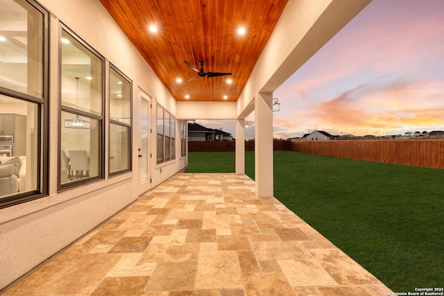 patio terrace at dusk with a lawn and ceiling fan