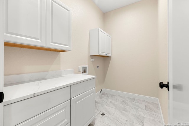 clothes washing area with cabinets, hookup for an electric dryer, and hookup for a washing machine