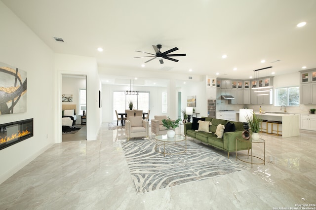 living room featuring ceiling fan, plenty of natural light, and sink