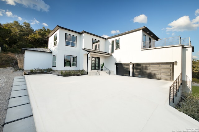 view of front facade with a balcony, french doors, and a garage