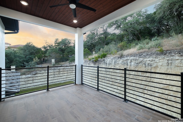 patio terrace at dusk with a balcony and ceiling fan