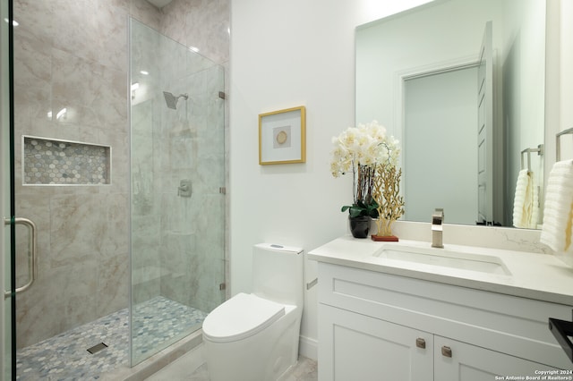 bathroom featuring a shower with door, vanity, and toilet