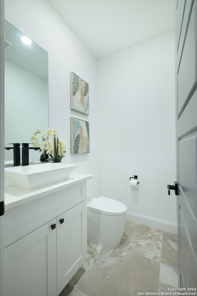 bathroom featuring vanity and toilet