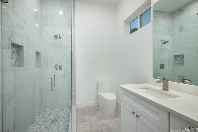 bathroom featuring vanity, toilet, and a shower with shower door