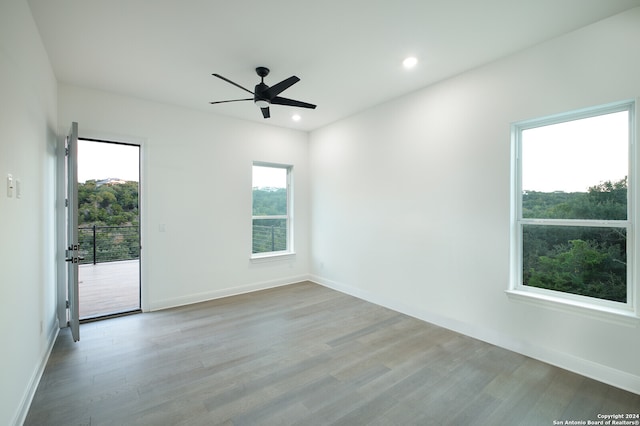 spare room with light wood-type flooring, plenty of natural light, and ceiling fan