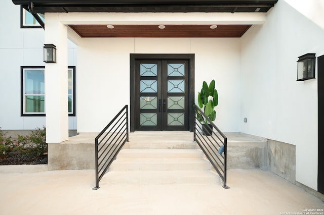 property entrance with covered porch and french doors