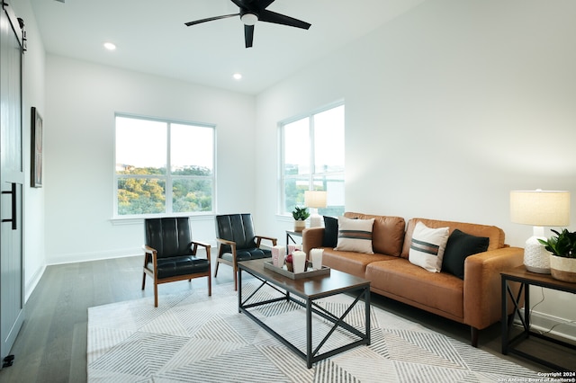 living room featuring a barn door, ceiling fan, and hardwood / wood-style floors