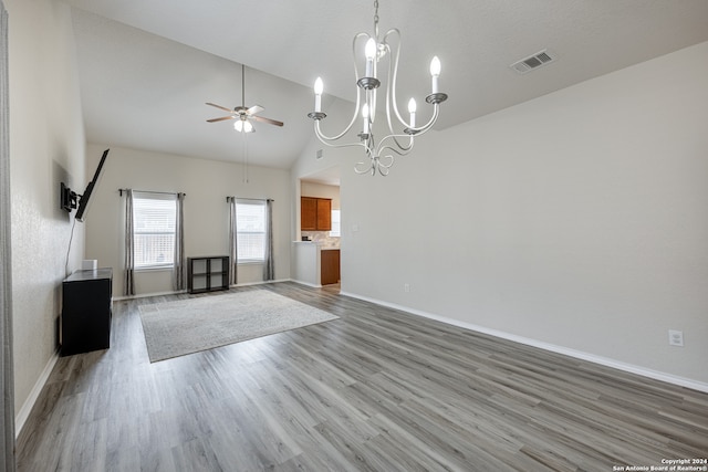 unfurnished living room featuring hardwood / wood-style flooring, high vaulted ceiling, and ceiling fan with notable chandelier