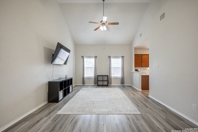 unfurnished living room featuring high vaulted ceiling, light wood-type flooring, and ceiling fan