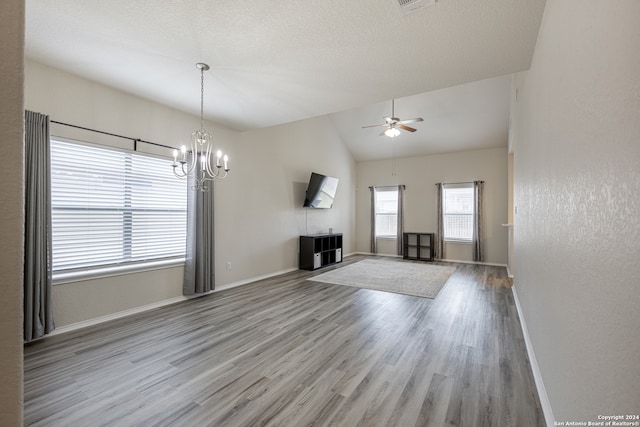 interior space with vaulted ceiling, ceiling fan with notable chandelier, and light hardwood / wood-style floors