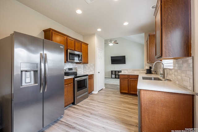 kitchen with sink, backsplash, light hardwood / wood-style floors, stainless steel appliances, and lofted ceiling