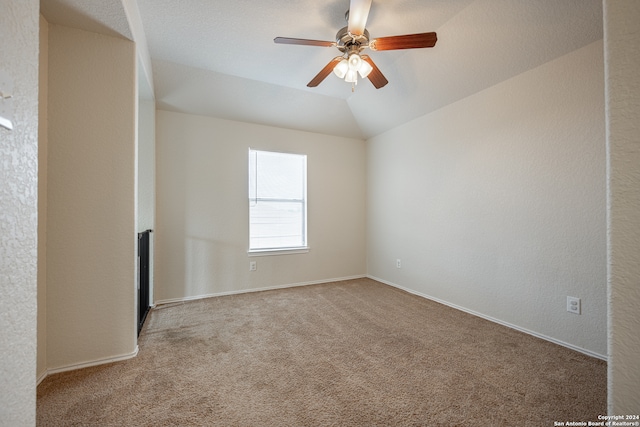 carpeted empty room with lofted ceiling and ceiling fan