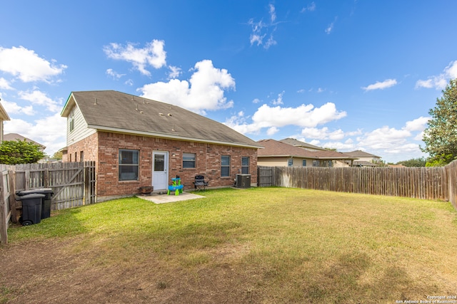 back of property with a patio area, central air condition unit, and a lawn