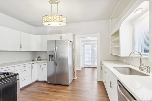 kitchen featuring appliances with stainless steel finishes, sink, plenty of natural light, and white cabinets