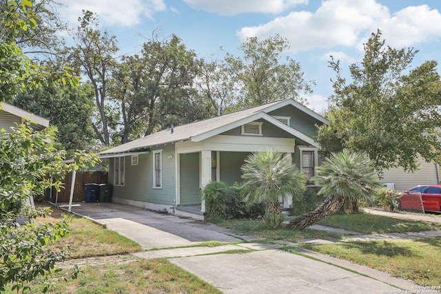 1112 W Huisache Ave, San Antonio, TX 78201 - view of front of home featuring fence, driveway, an attached carport, and covered porch