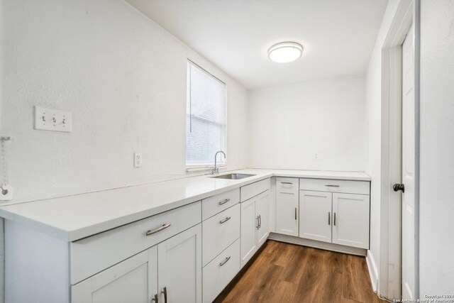1112 W Huisache Ave, San Antonio, TX 78201 - kitchen with dark wood-type flooring, a sink, white cabinetry, and light countertops